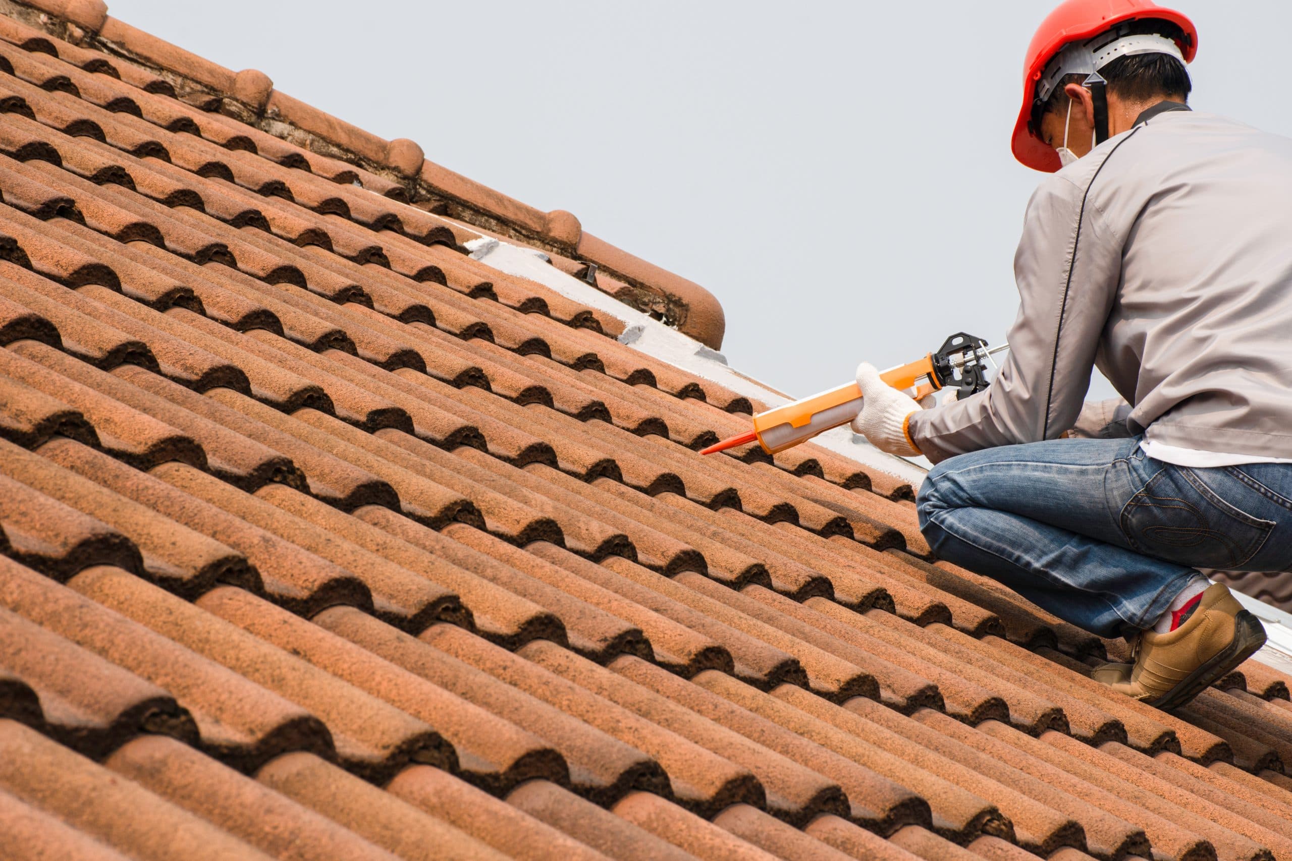 Roofer installing emergency tarping on a storm-damaged Arizona roof