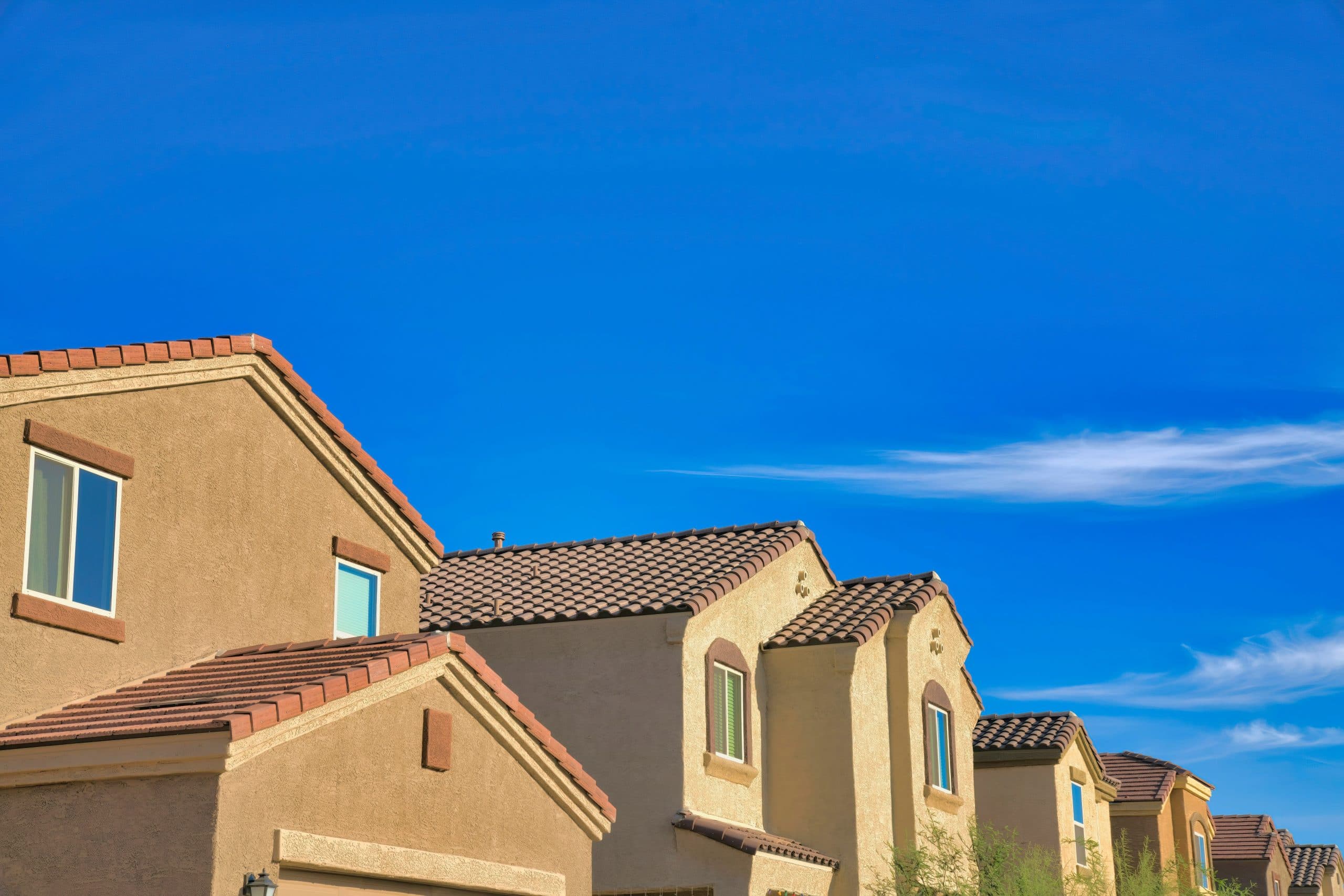Arizona homes with clay tile roofs under a blue sky